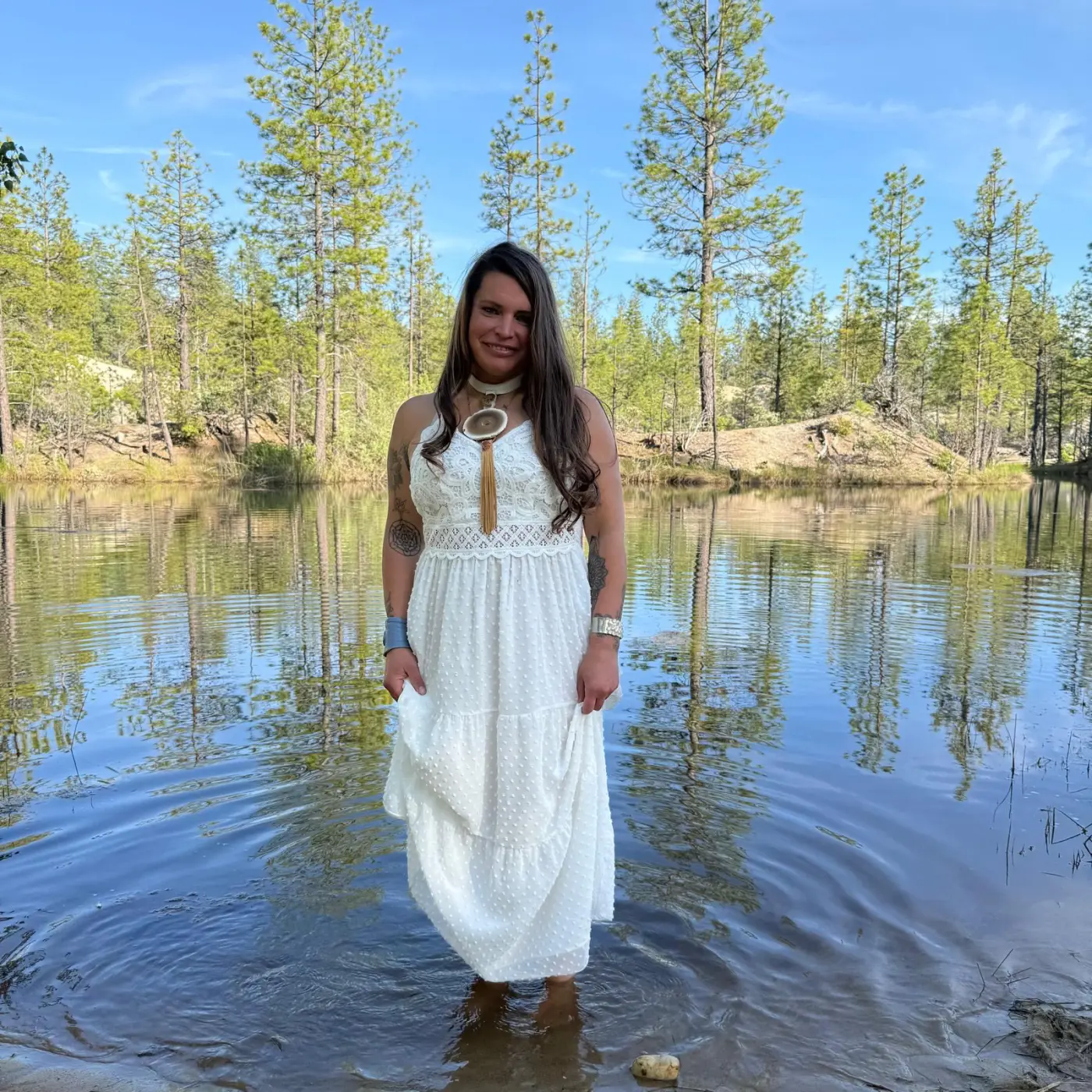 Athena Rose standing in the still water of a forest pond